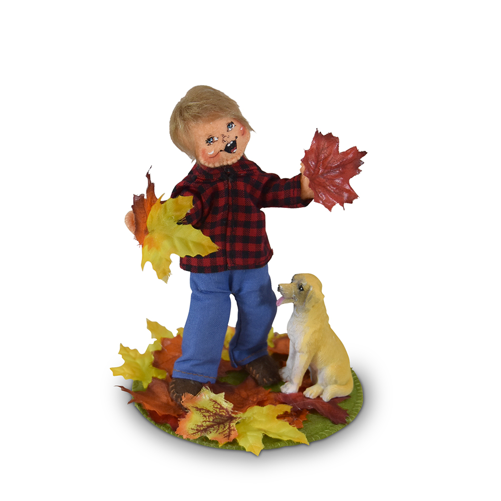boy playing with dog in autumn leaves